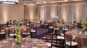 Ballroom with purple carpets and round tables with rose linens