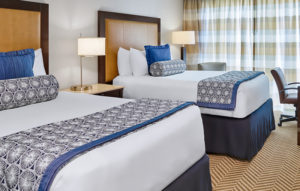 Double bed guestroom with white and blue linens