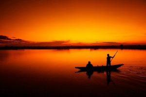 Bright orange sunset with fishermen silhouettes